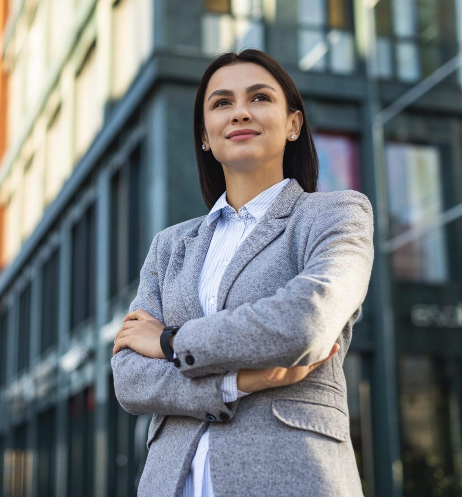 low-angle-businesswoman-posing-with-arms-crossed-outdoors