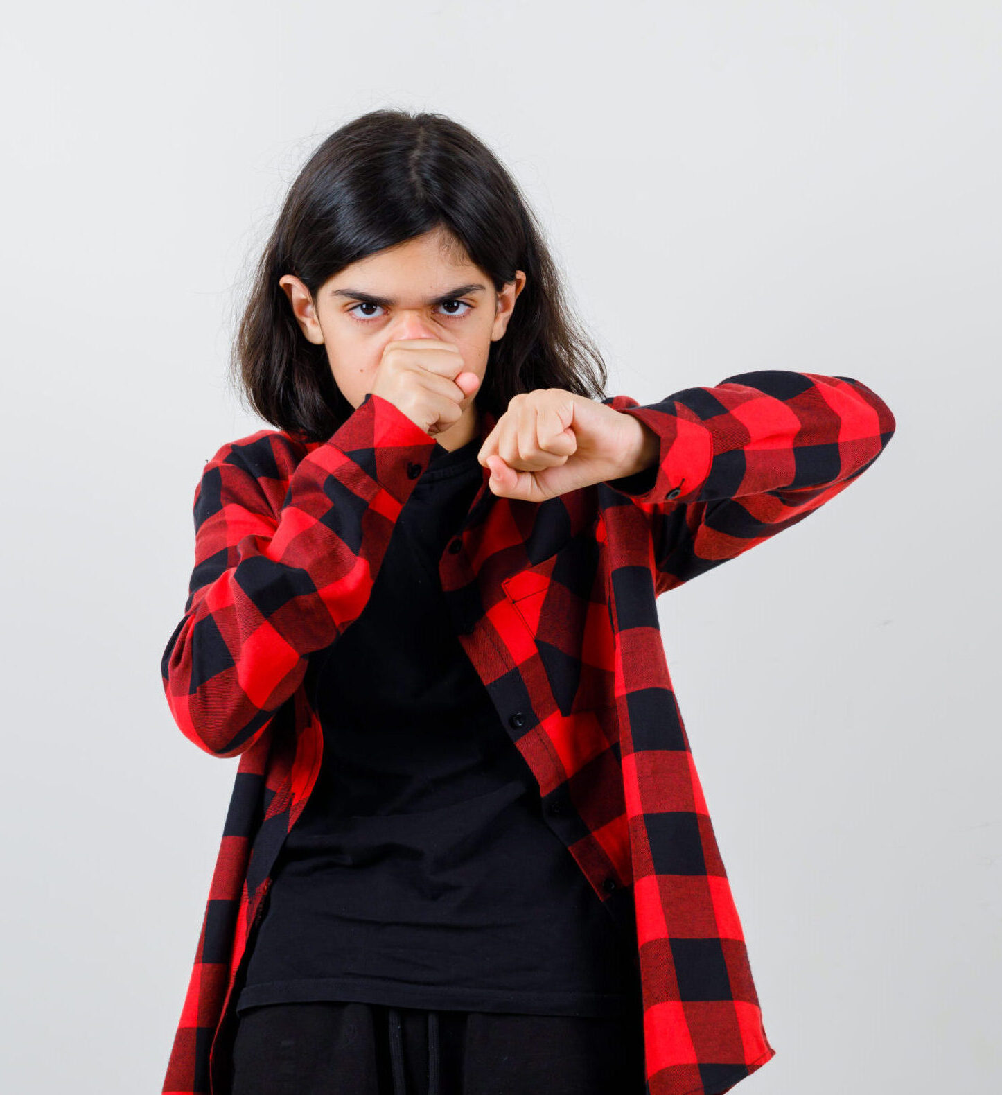 teen girl in t-shirt, checkered shirt standing in fight pose and looking self-confident , front view.